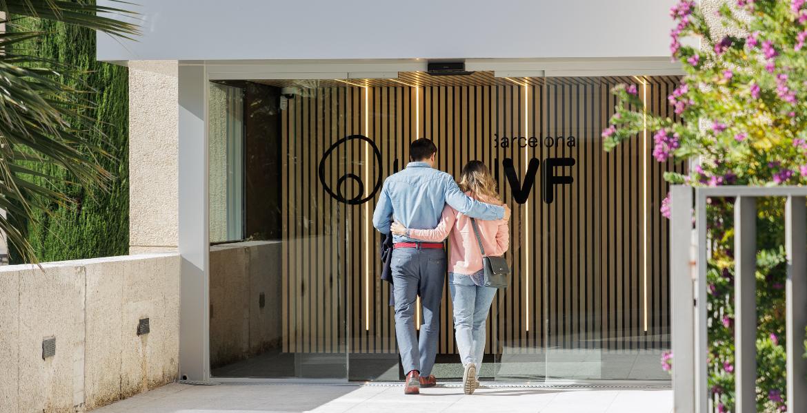 Couple walking arm in arm towards the entrance of Barcelona IVF Clinic, preparing for fertility treatment.
