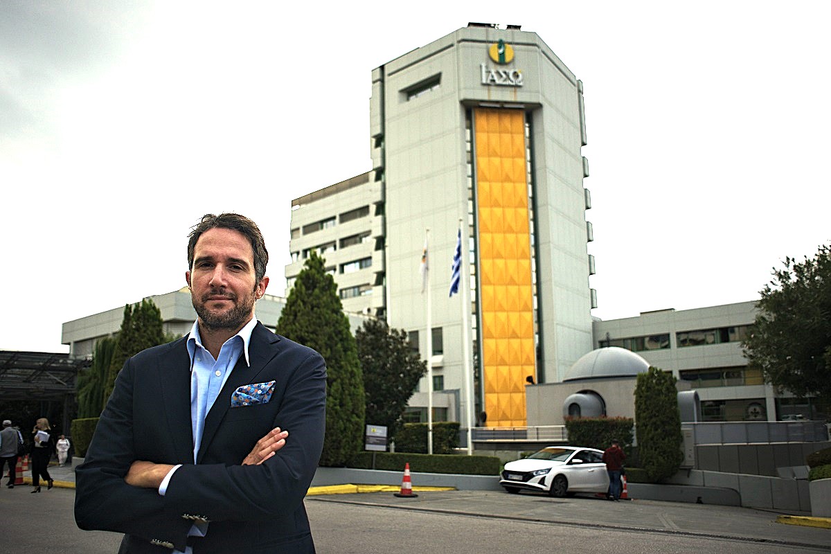 Fertility specialist standing in front of the modern IASO IVF clinic building in Athens, Greece – gynecology, in vitro fertilization, reproductive medicine.